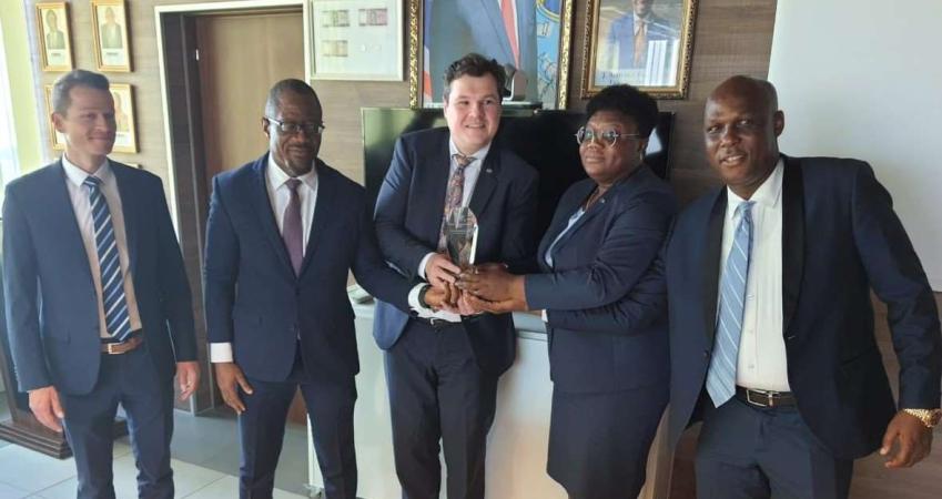 CBL Executive Governor J. Aloysius Tarlue, Jr. (second from left) receives the award from Messrs. Ulrich Rebele, Regional Sales Director of G+D and Alexander Huber, Product Manager for Security Threads of G +D.