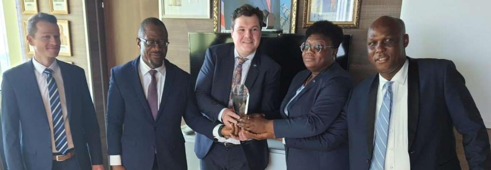 CBL Executive Governor J. Aloysius Tarlue, Jr. (second from left) receives the award from Messrs. Ulrich Rebele, Regional Sales Director of G+D and Alexander Huber, Product Manager for Security Threads of G +D.